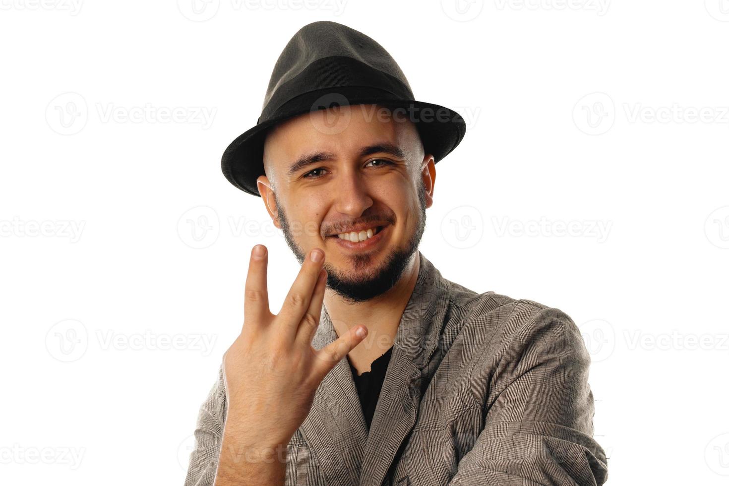 young cheerful unshaved man in hat and jacket looking at the camera and smiling photo