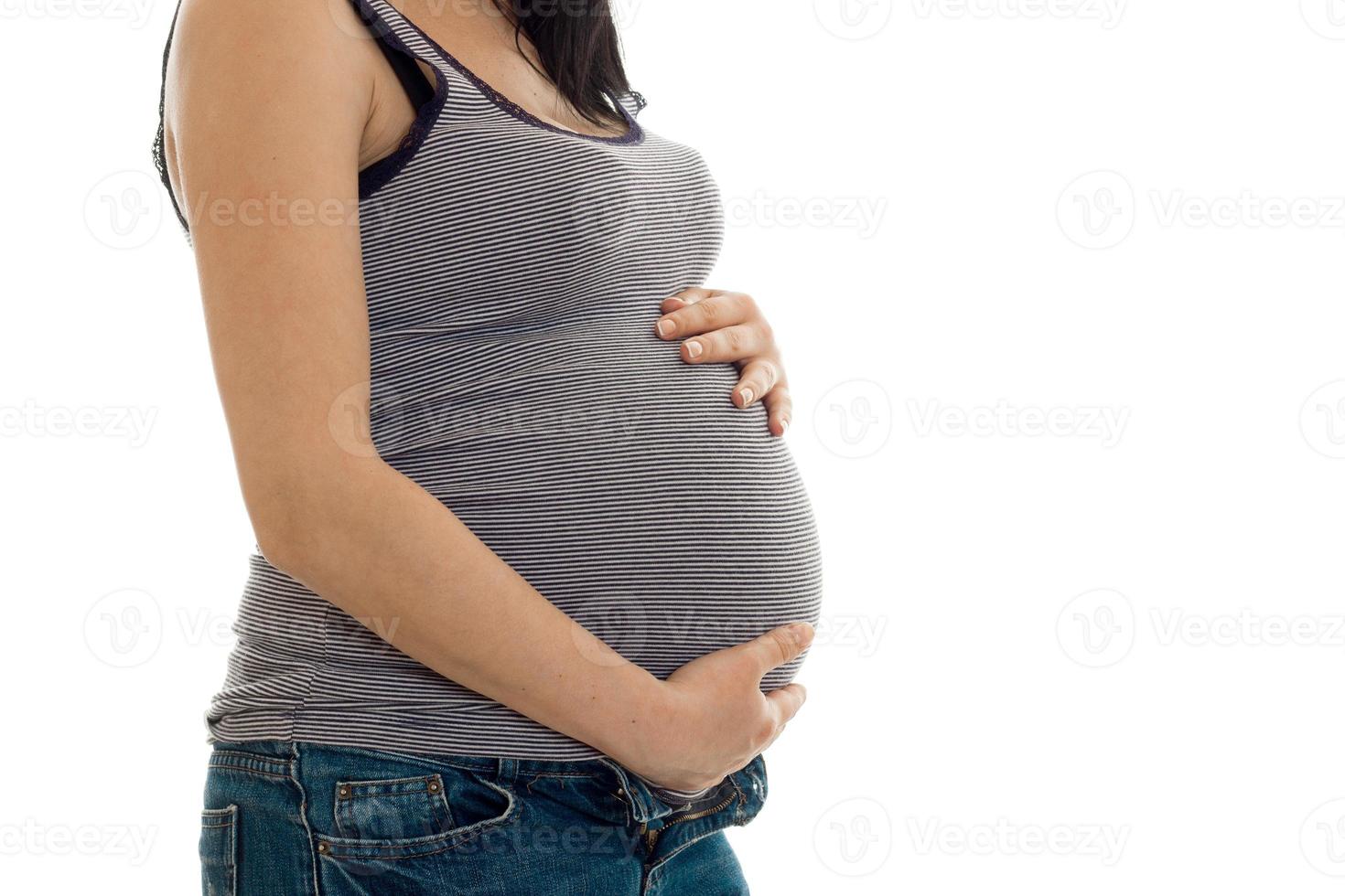 joven embarazada posando aislada sobre fondo blanco sin rostro foto