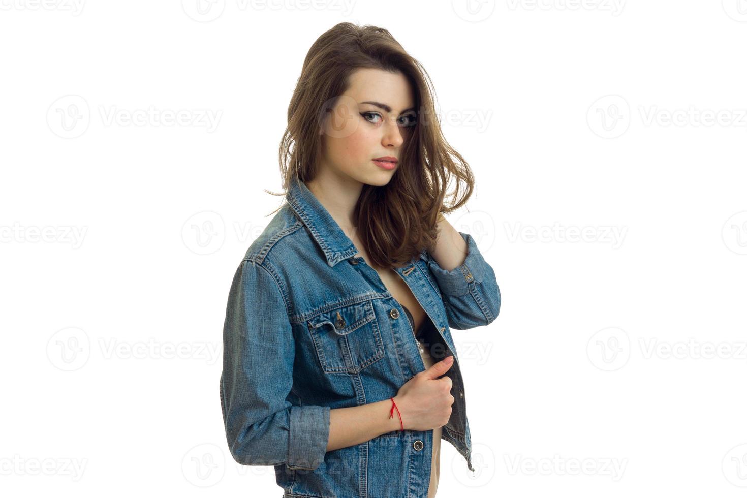 charming brunette in jeans jacket looks into a camera close-up photo