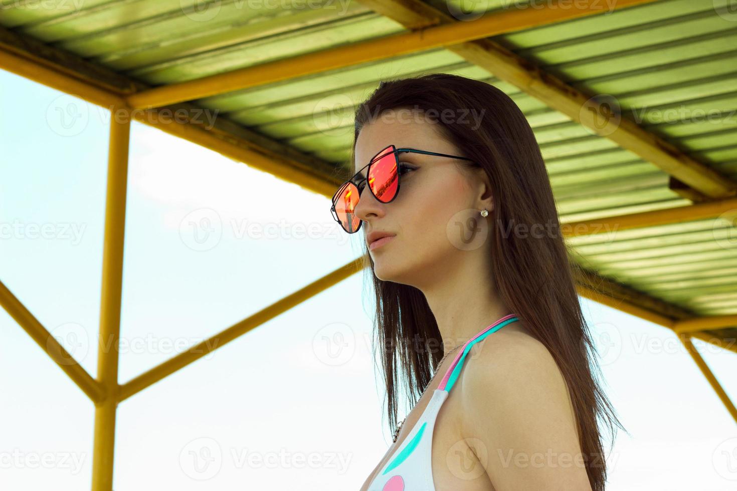 portrait of young girl in sunglasses and swimsuit photo