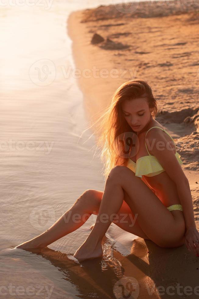 young sexy girl at sunset at the beach photo