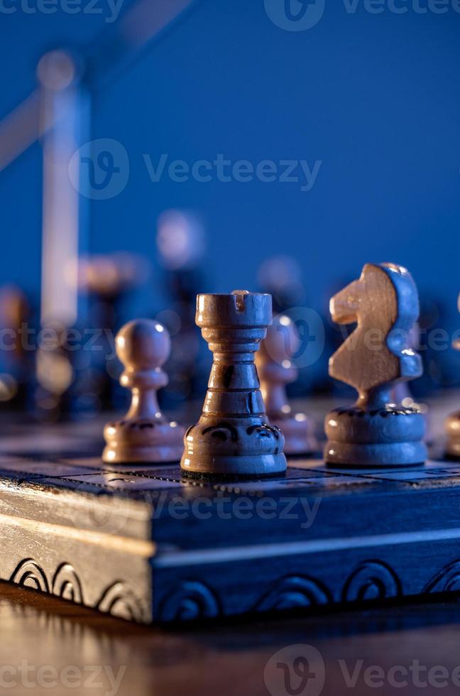 Chess board with chess pieces on blue background. Concept of business ideas and competition and strategy ideas. White rook close up. photo