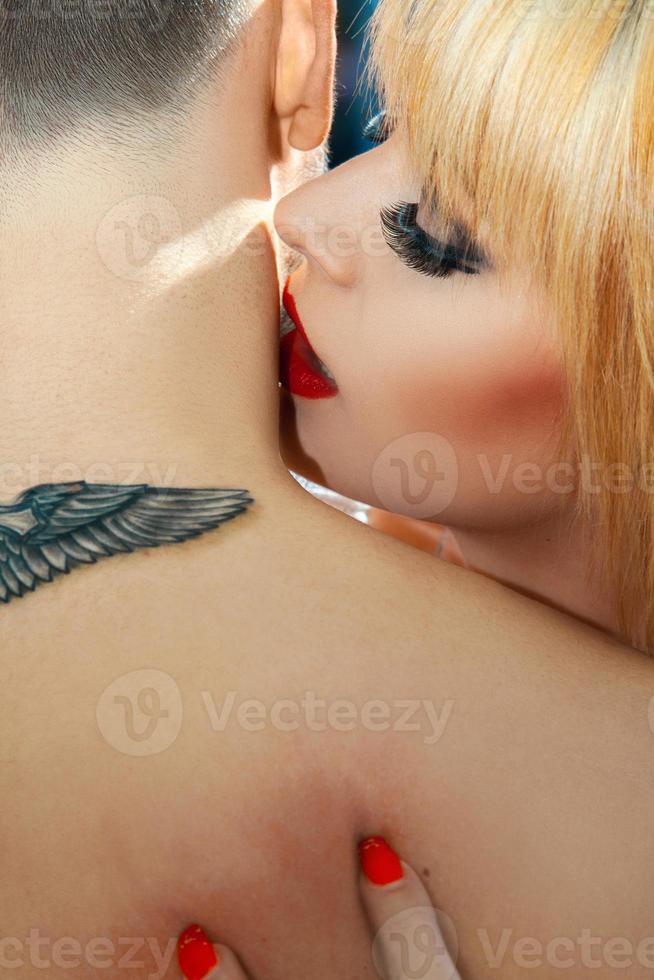 Seductive woman kissing her boy in neck photo