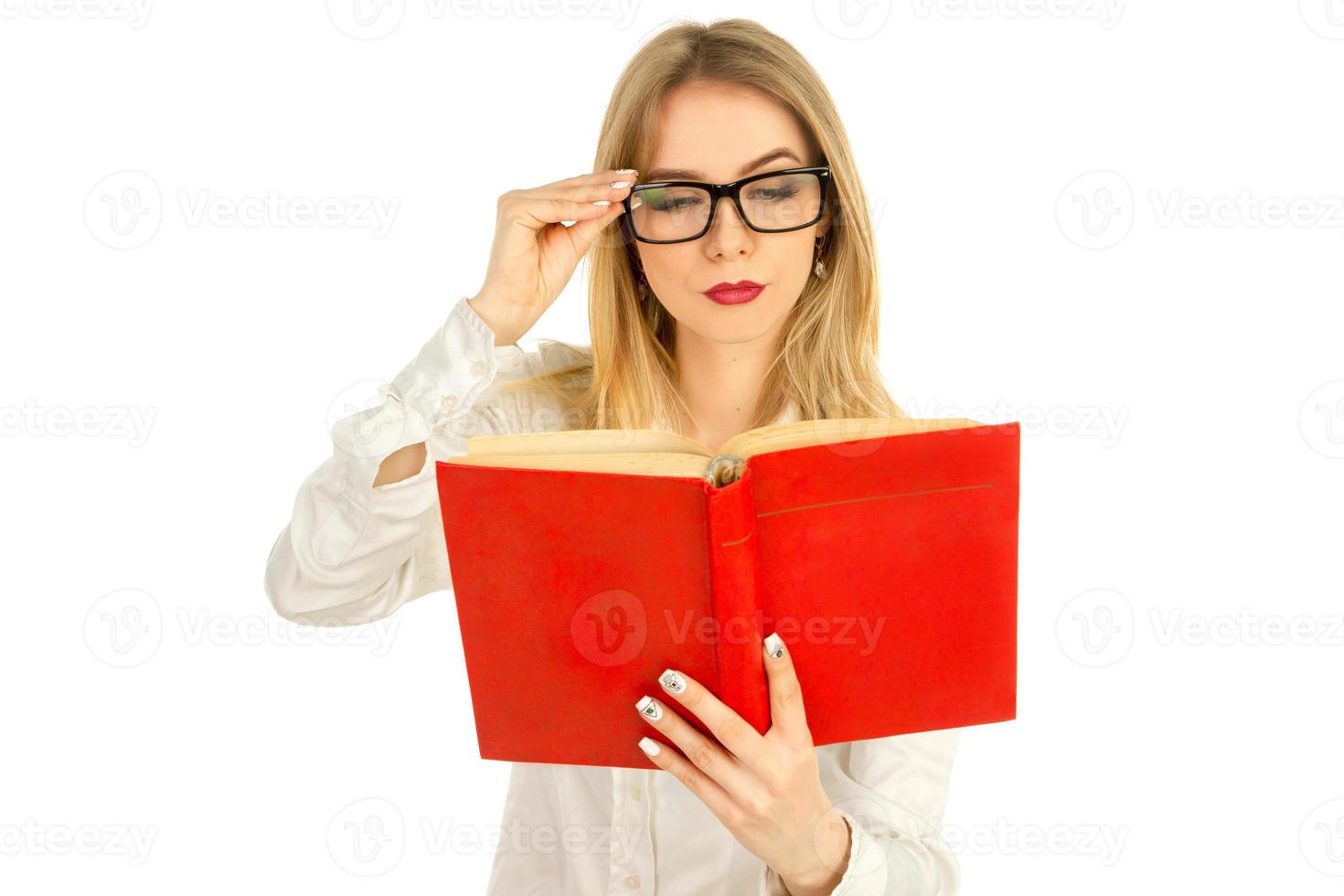 girl in glasses and a white shirt reading a book photo