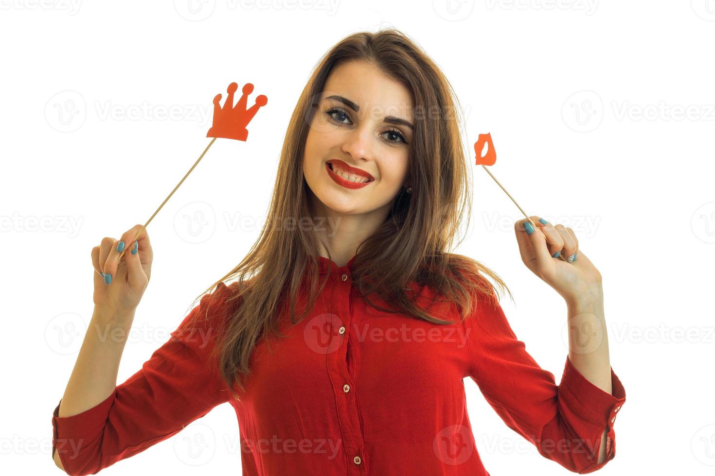 hermosa chica alegre con pintalabios rojo sostiene esponjas y corona de papel y sonriente foto