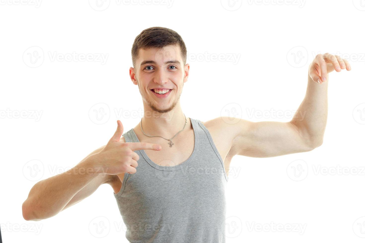 young gay guy in sports athletic shaped body straining muscle on hand photo