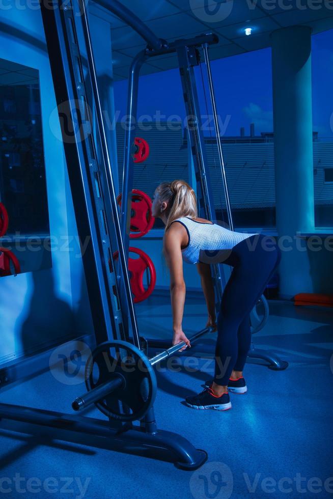 Vertical photo of pretty fitness model with barbell