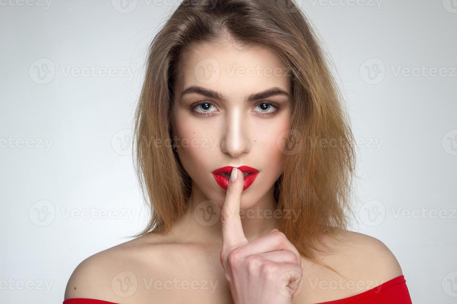 woman with red lips and finger at her mouth photo