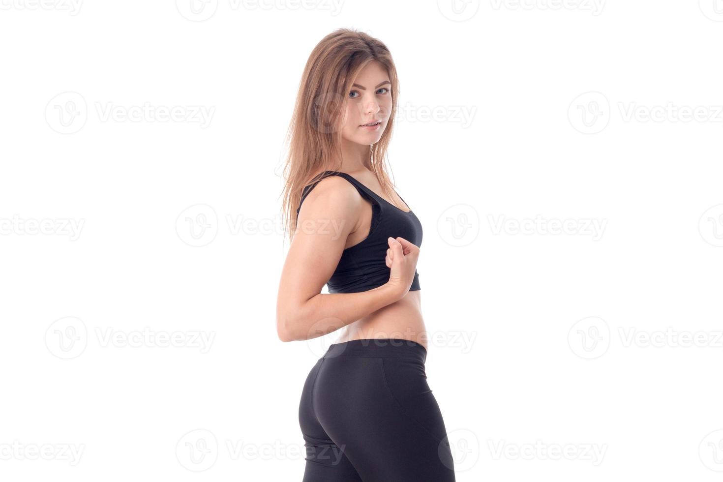 Fitness girl in black stands sideways isolated on white background photo