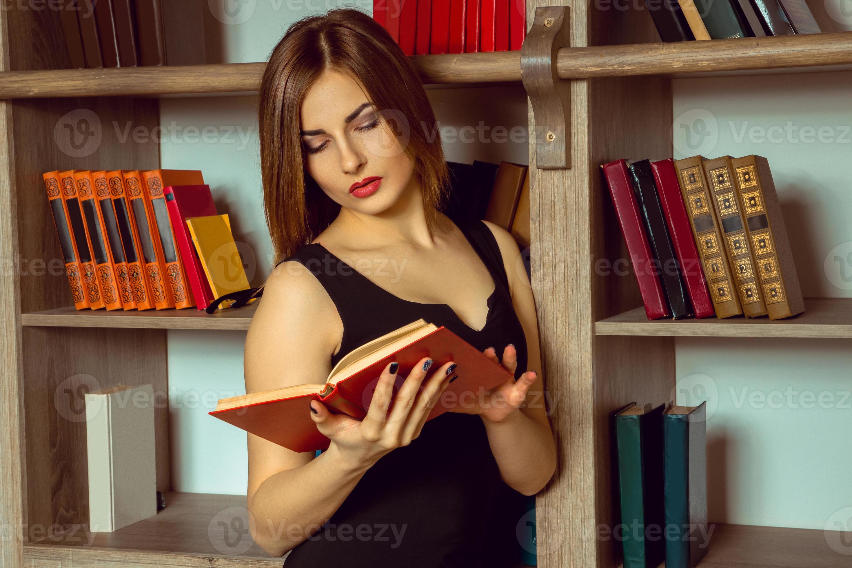 beautiful librarian reads a book 16096328 Stock Photo at Vecteezy