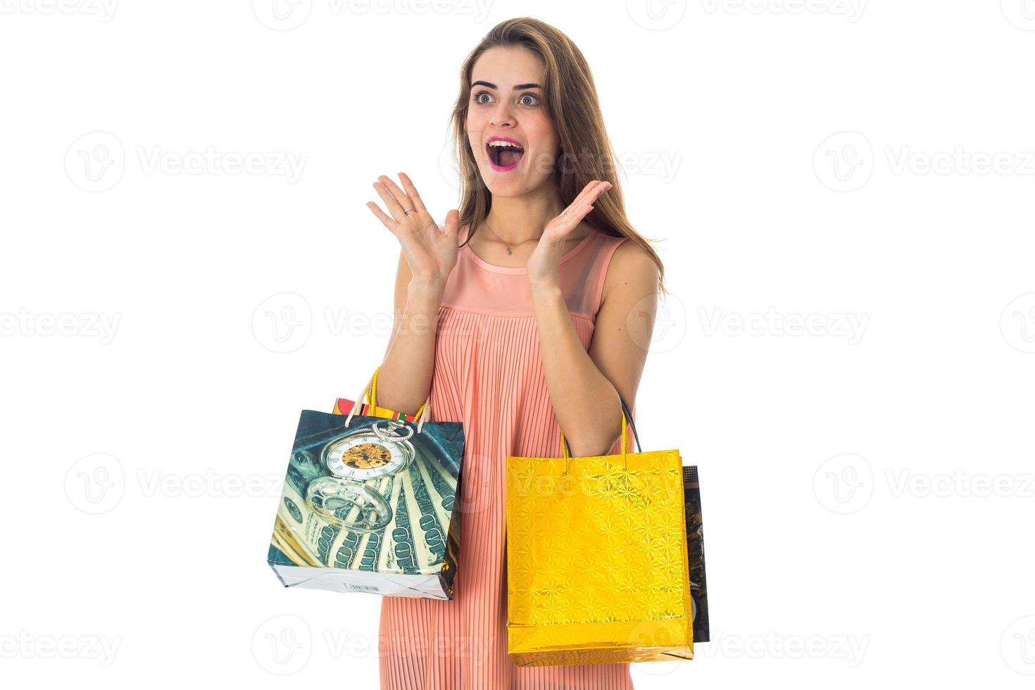 young girl wonders and keeps packages in hands isolated on white background photo