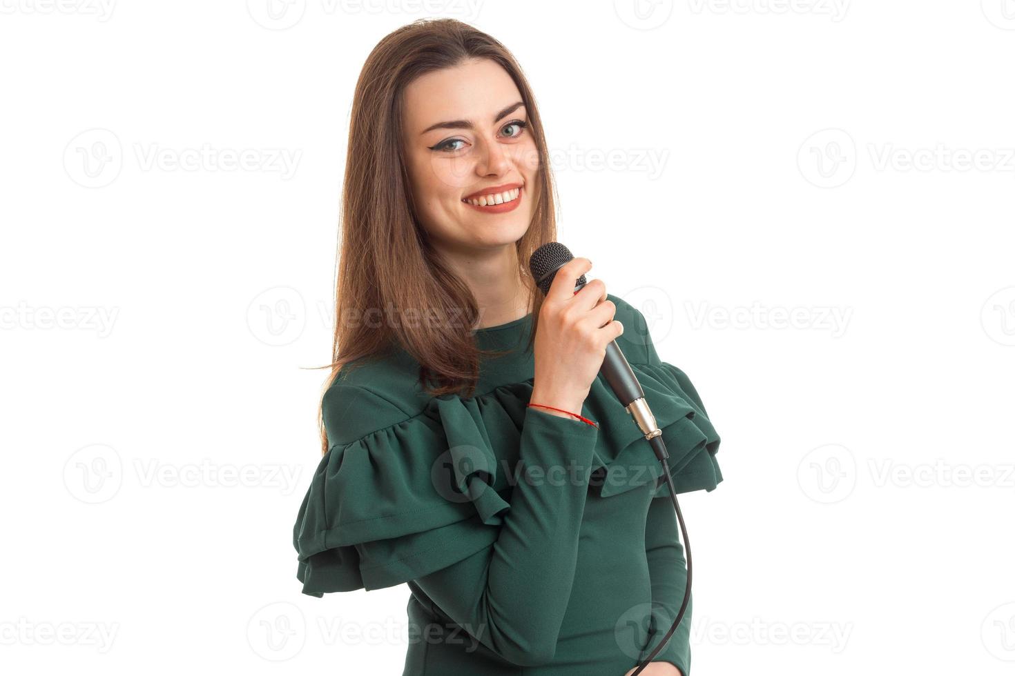 cheerful young woman in green dress singing song with karaoke photo