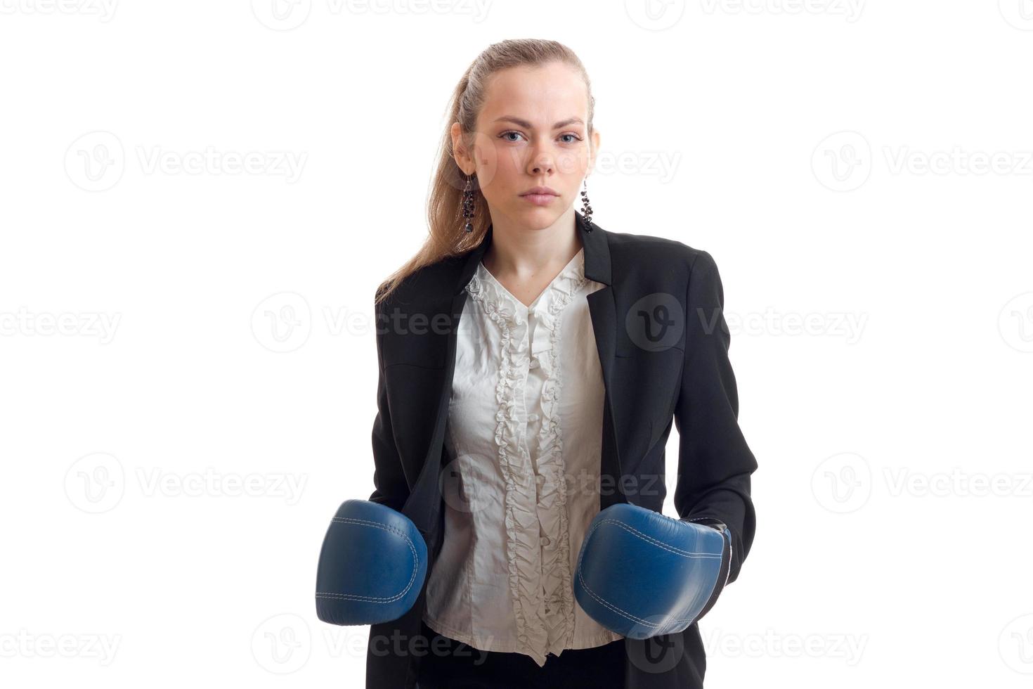 una joven con una chaqueta negra se puso guantes de boxeo en las manos y miró directamente foto