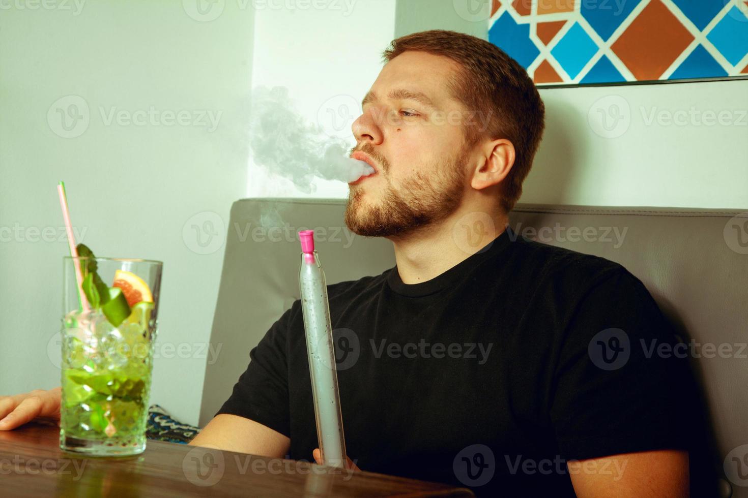 Beauty man smokes shisha photo