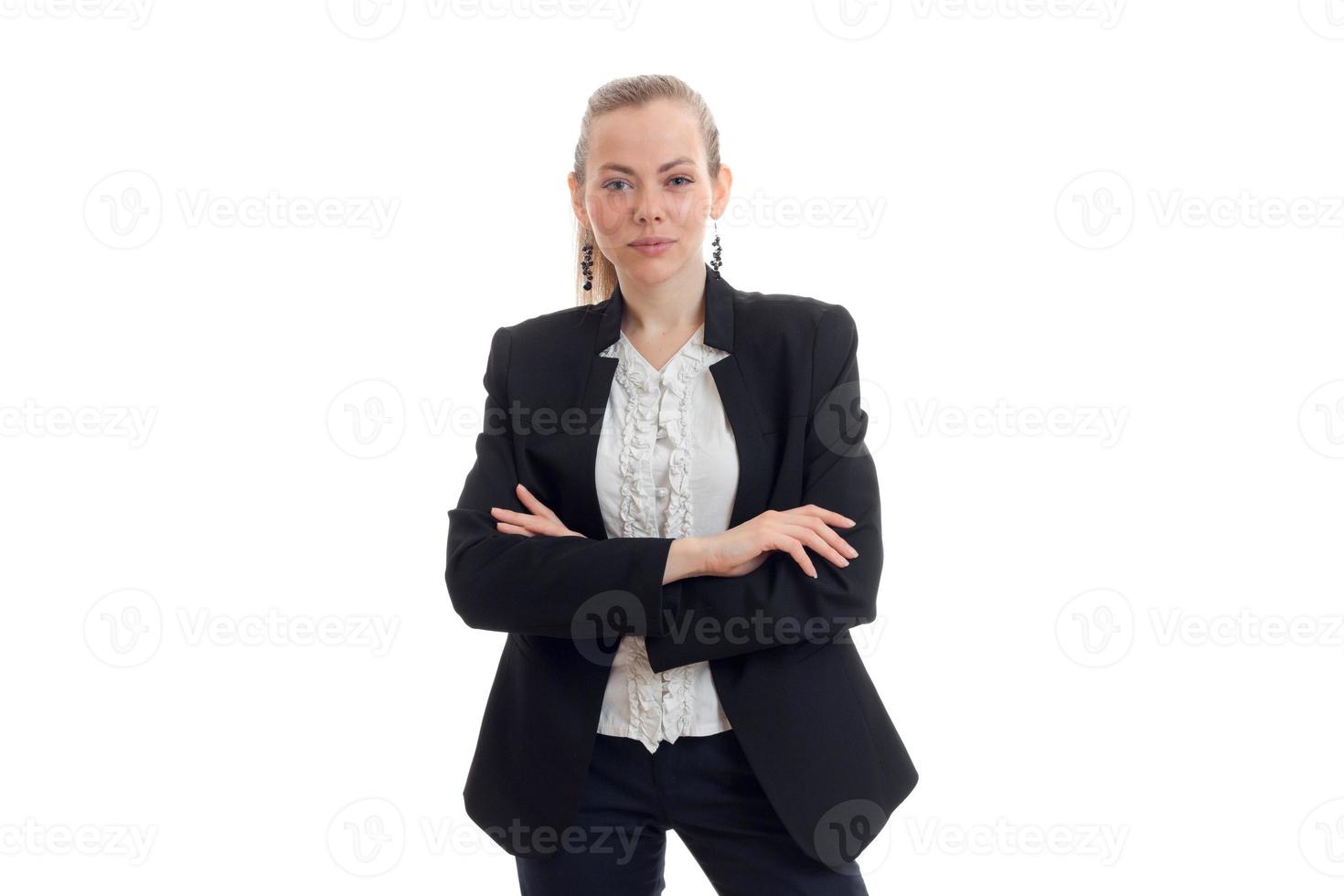 beautiful young girl in a black business suit stands with folded hands and looking directly photo