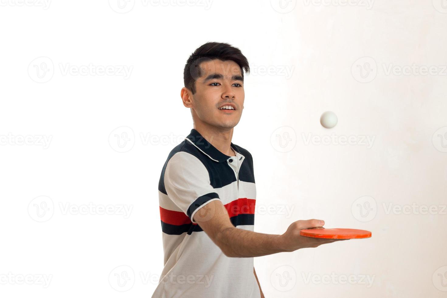 portrait of young sportsman practicing table tennis in uniform in studio photo