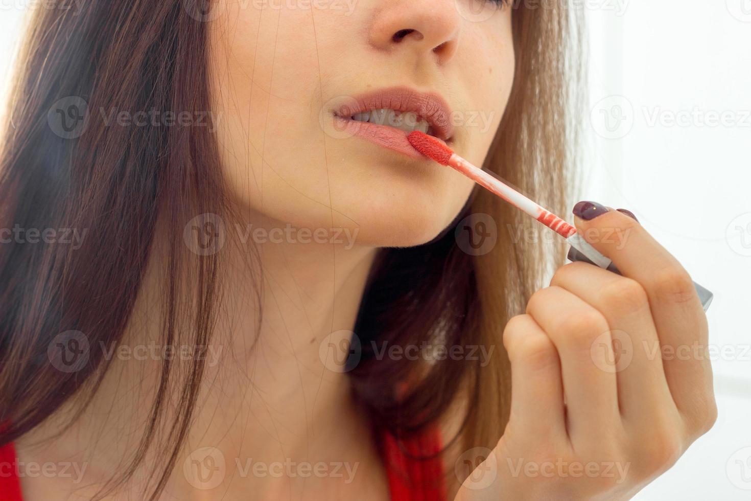 retrato de una joven que se pinta los labios con purpurina roja foto