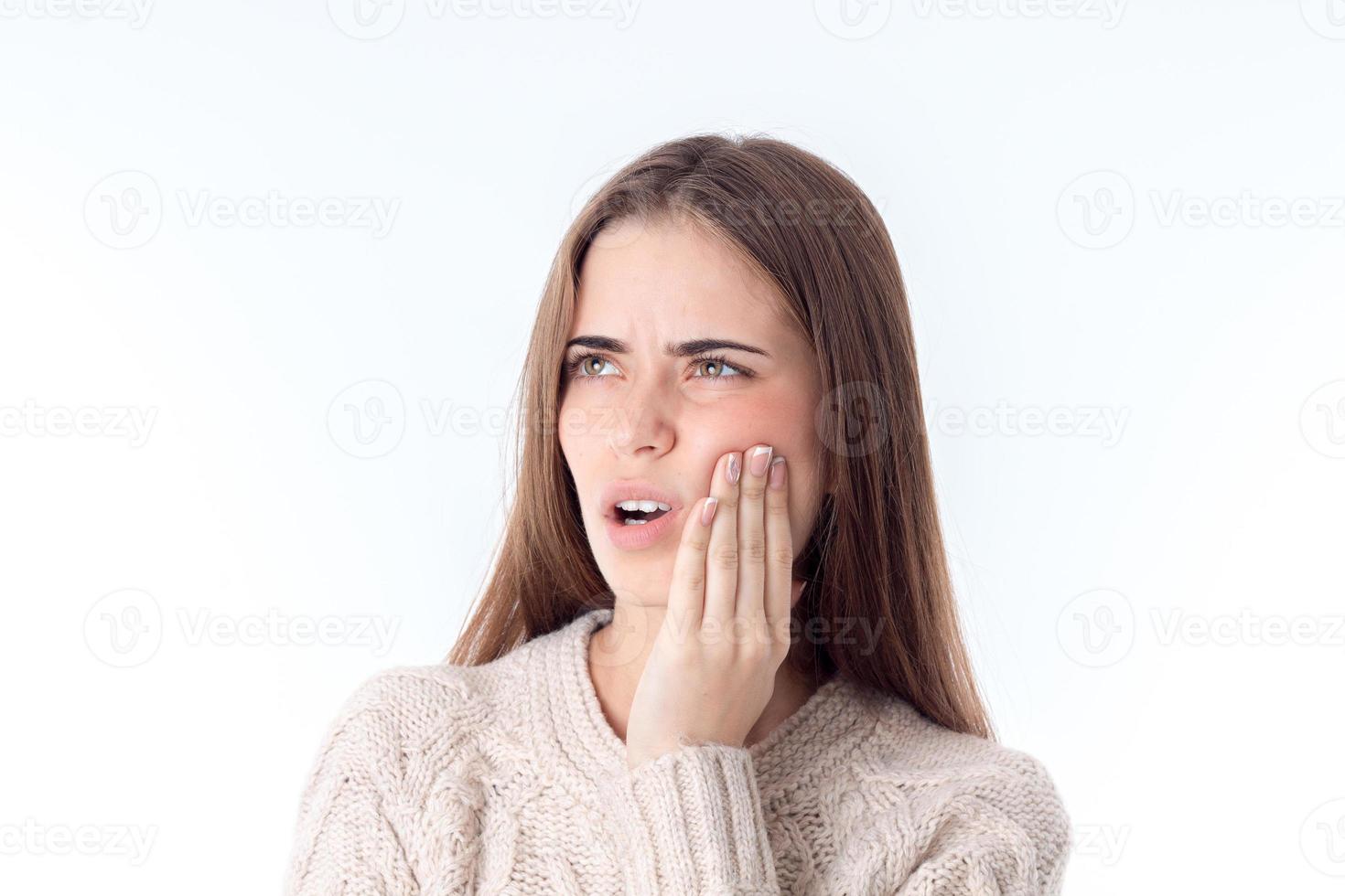 girl with severe dental pain keeps hand on cheek isolated white