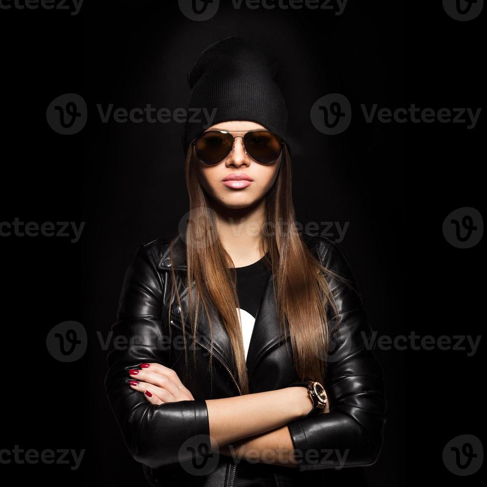 Woman in sunglasses looking at camera on black background photo