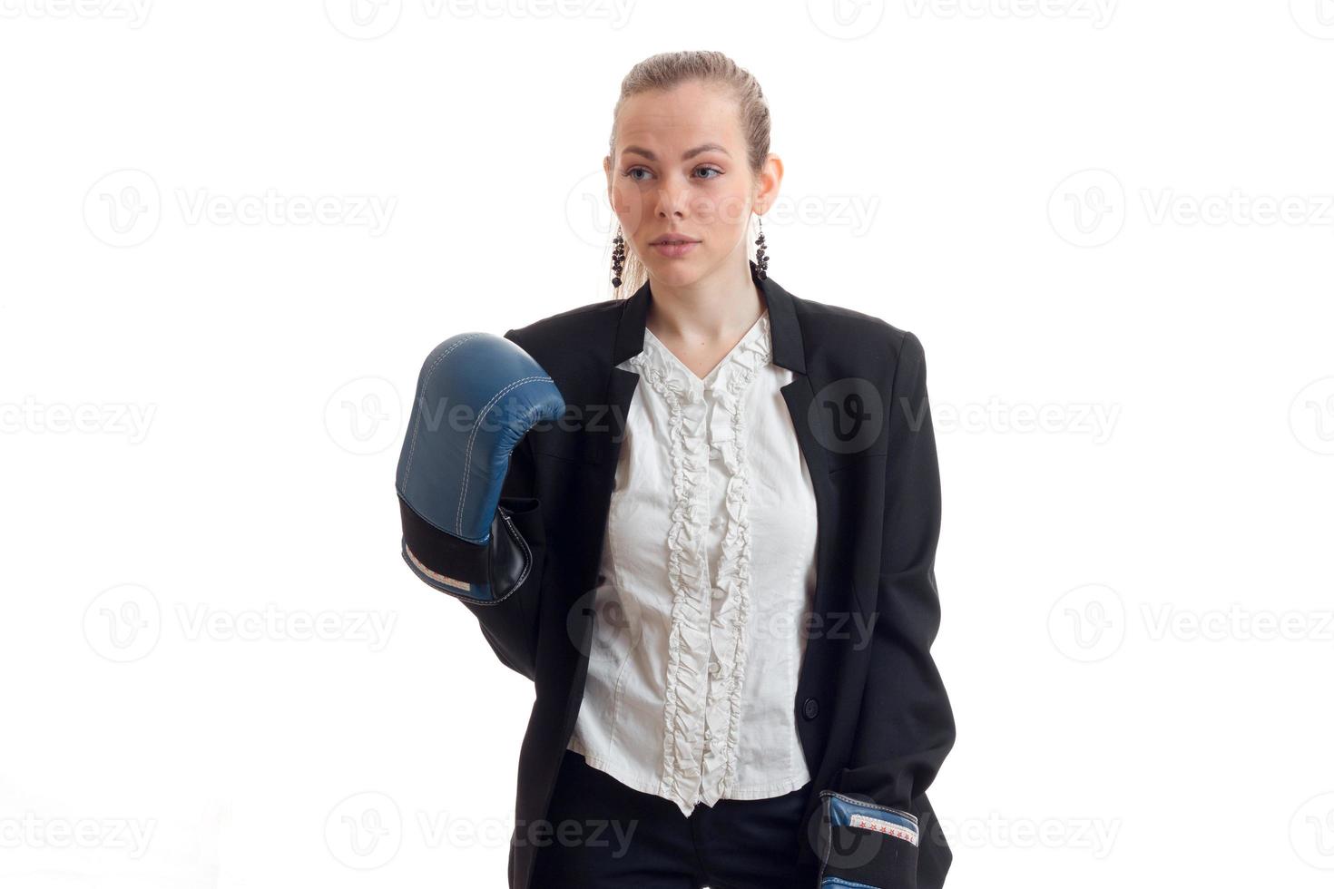 Business woman in classic uniform and boxing gloves looking aside in studio photo