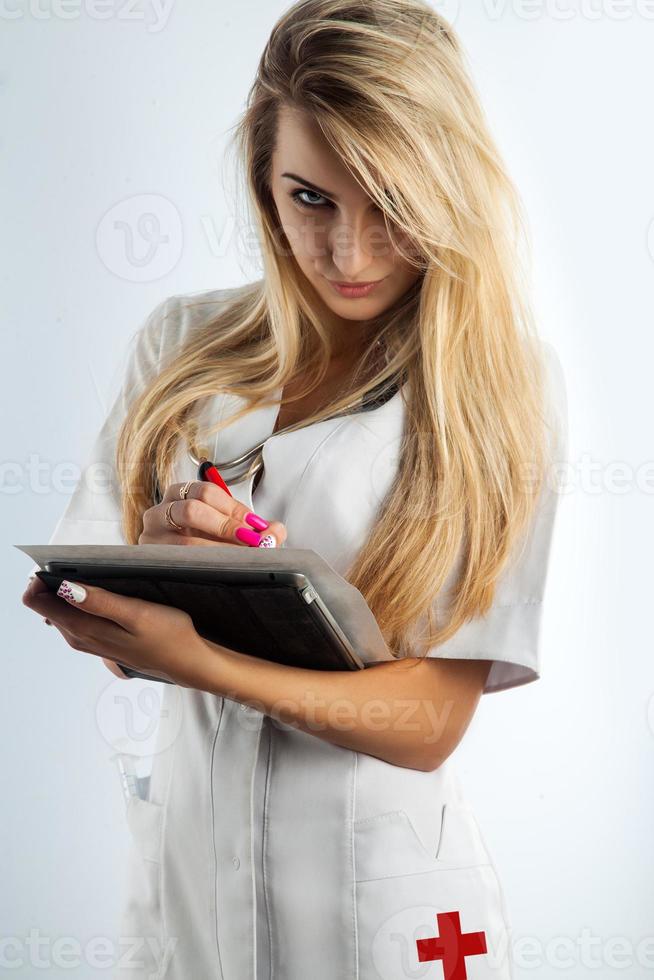 seductive blonde nurse writing on paper photo