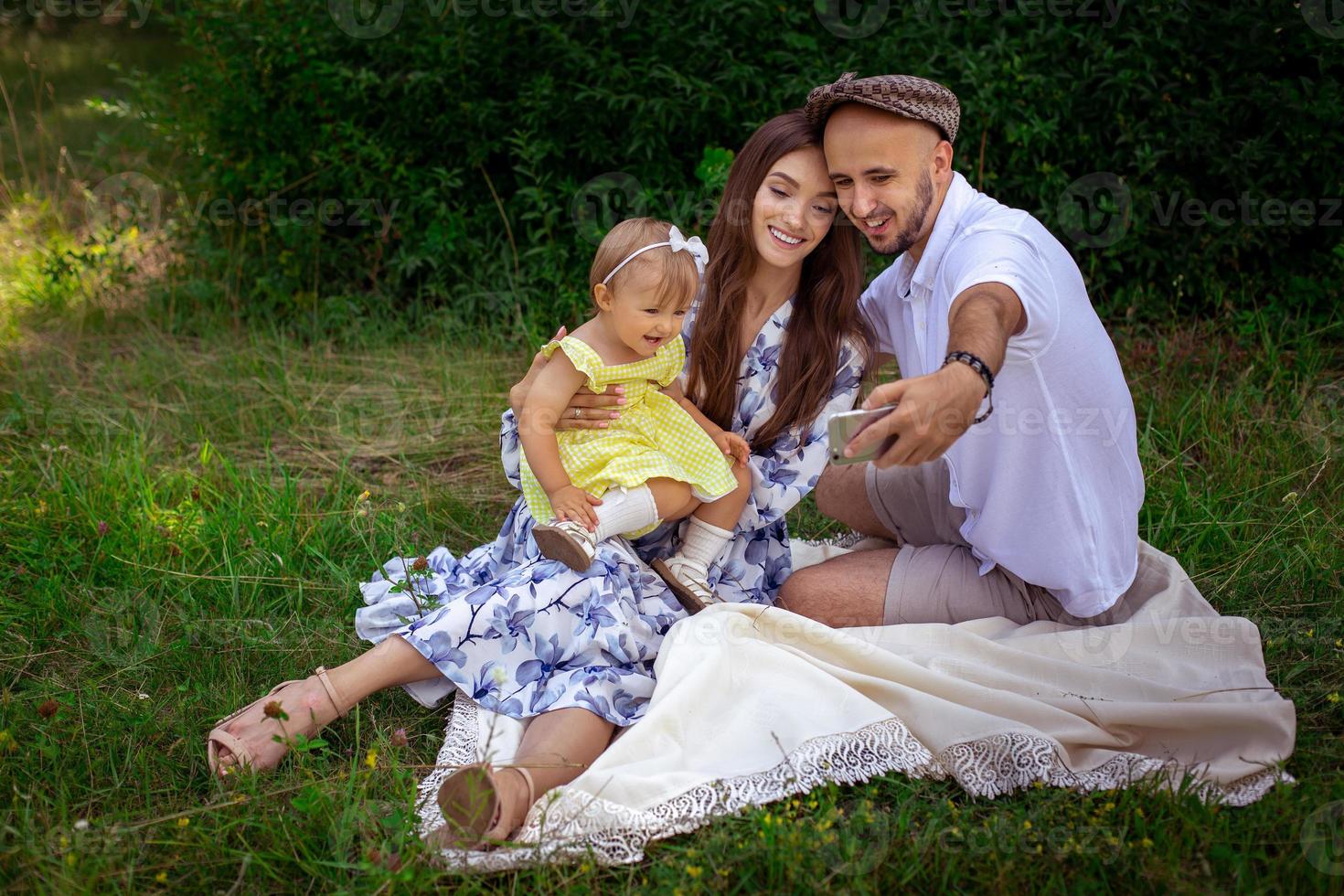 hermosa joven familia hace selfie en picnic foto