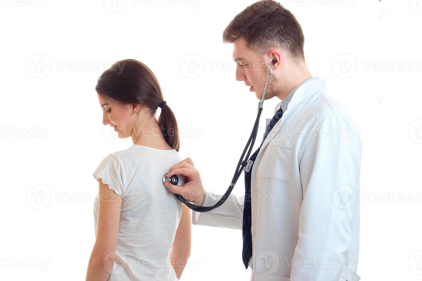 doctor examines a woman with a stethoscope photo