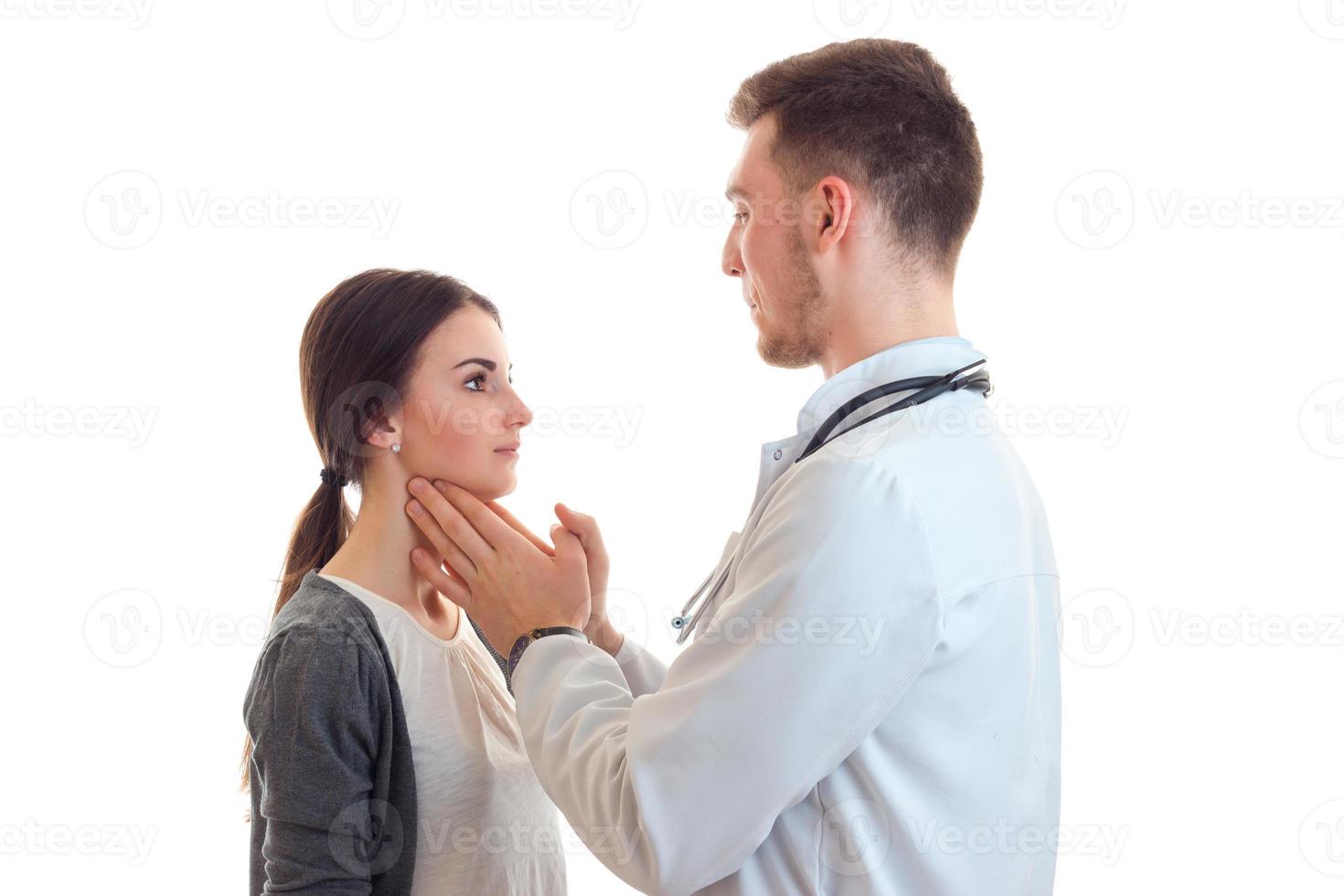 doctor in white robe touches hands throat young woman photo