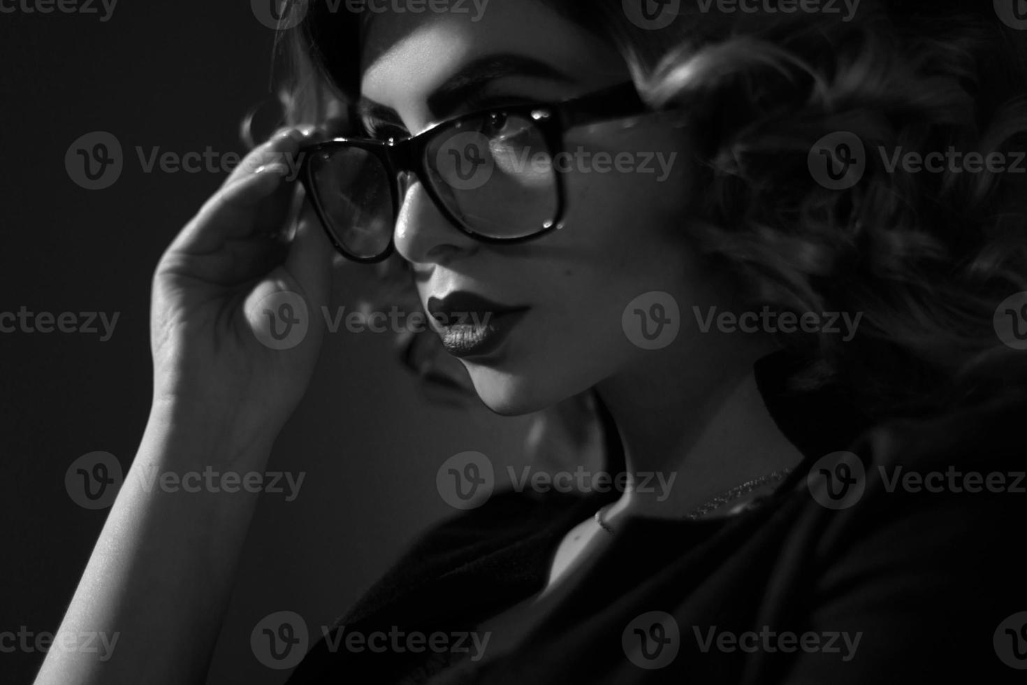 black and white photo of Sexy young secretary in glasses and curly hairstyle