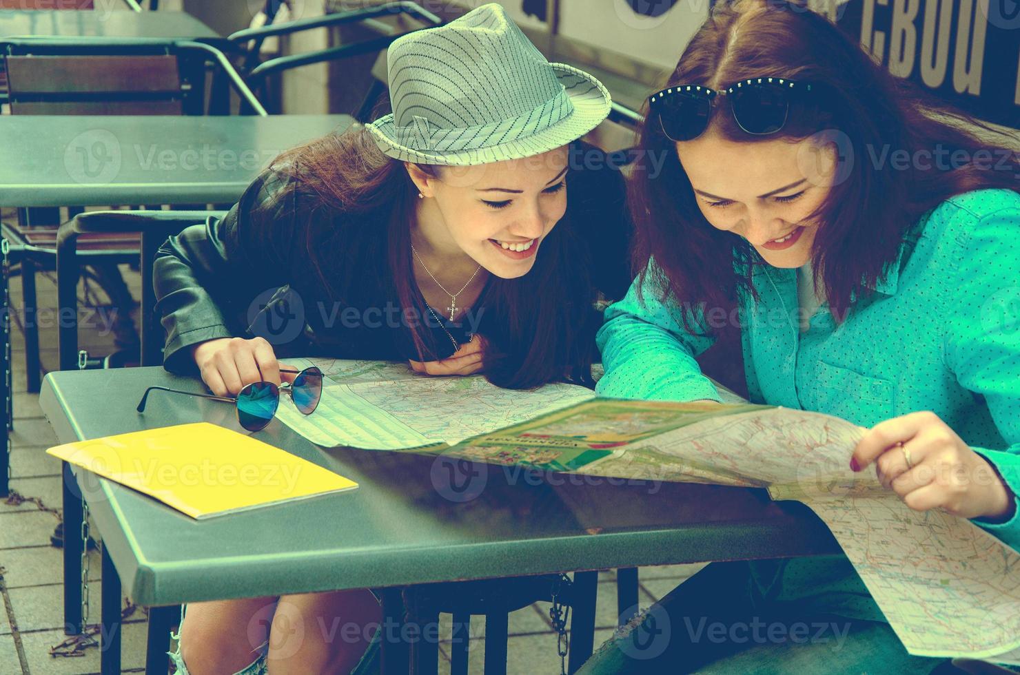 two women sitting at a table on the street photo