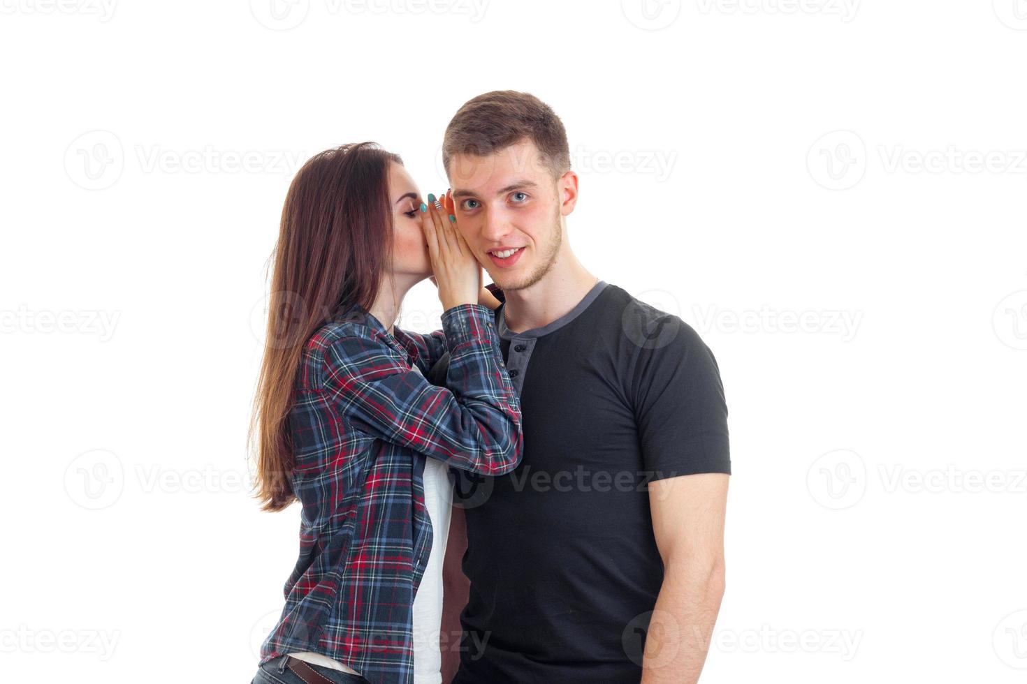 young girl whispering guy in his ear photo