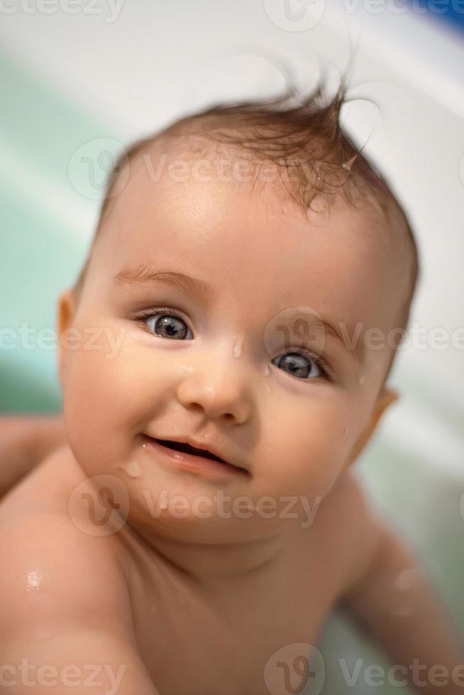 Cute newborn girl bathes in the bathroom photo
