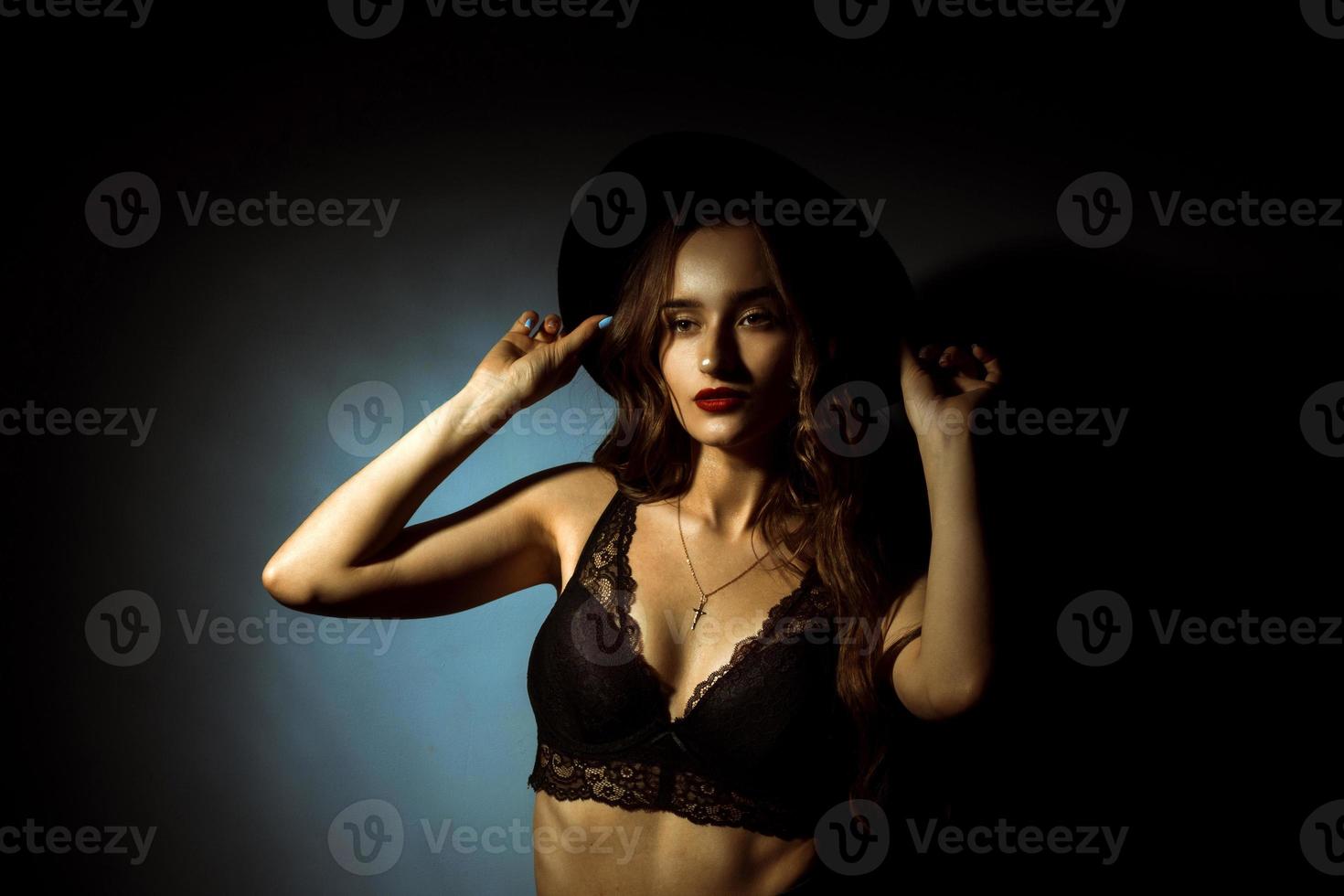 Gorgeous lady with curly hairstyle in dark studio photo