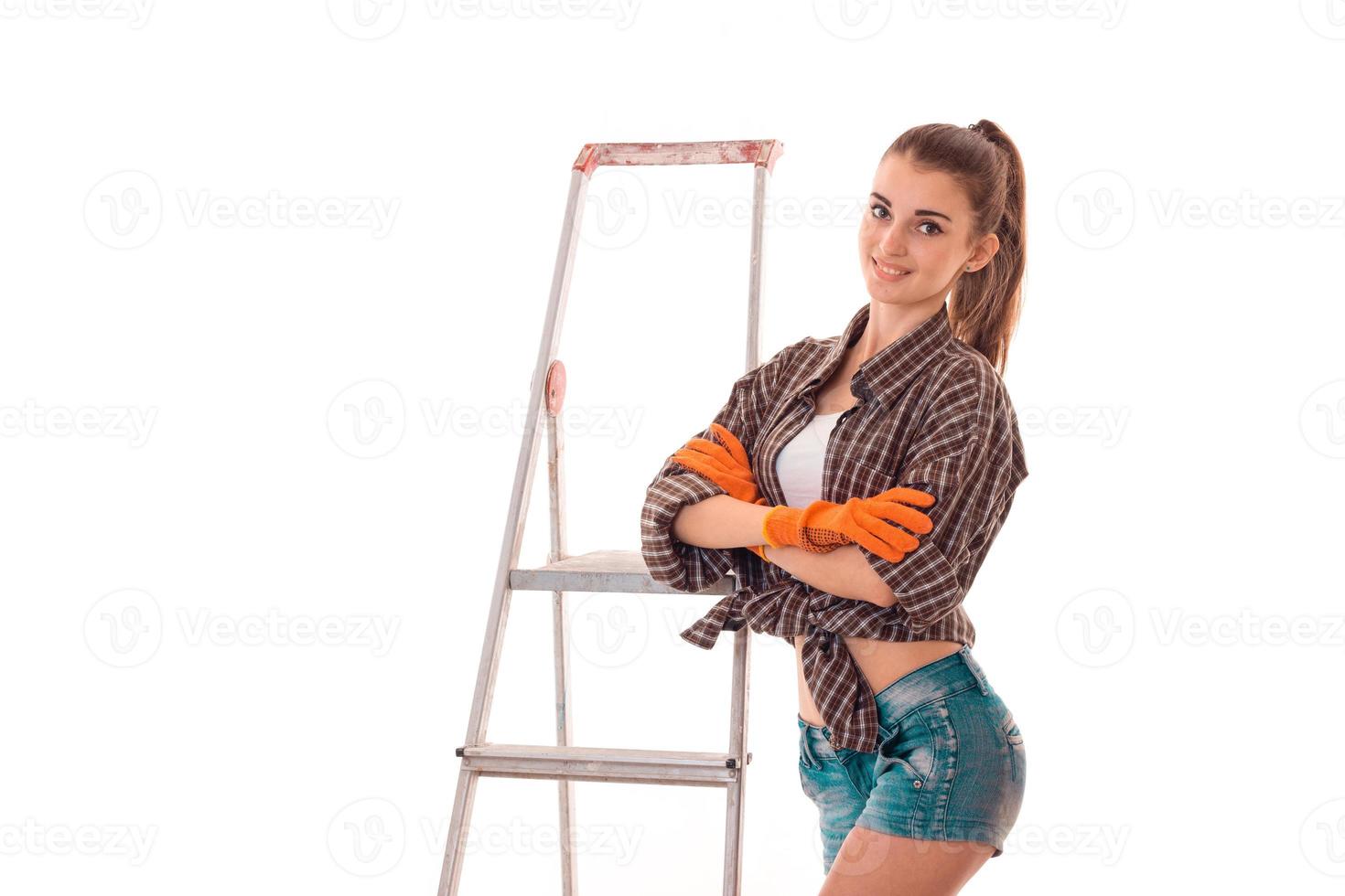 beautiful young girl in goggles short shorts and shirt stands near the stairs and looks into a camera photo