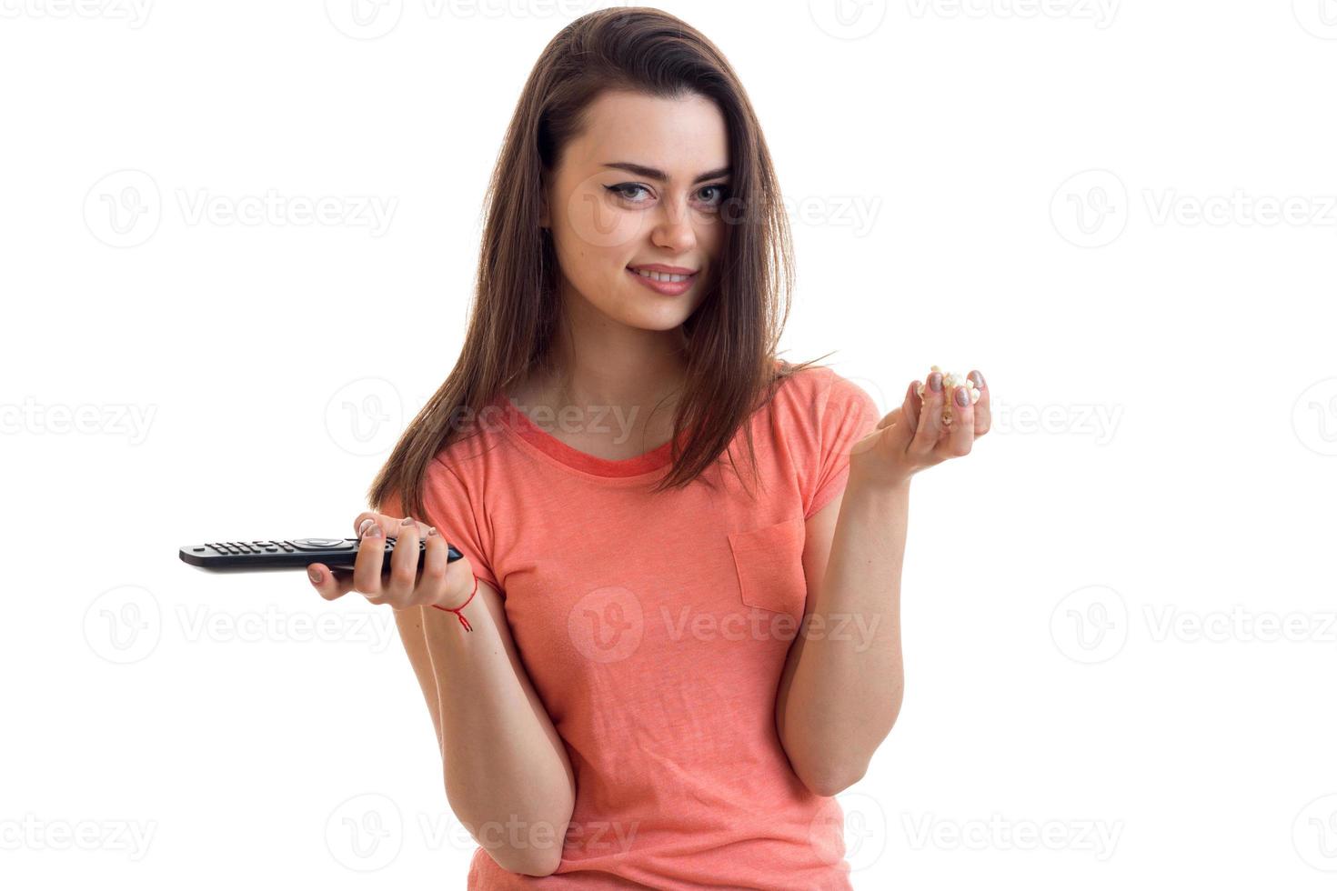smiling pretty girl looks into the camera and holds the remote in hand photo