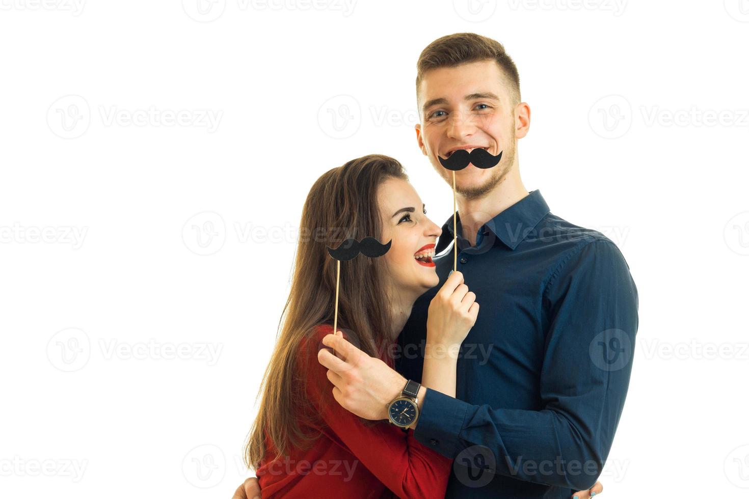 cheerful young girl and Guy are holding paper black whiskers photo