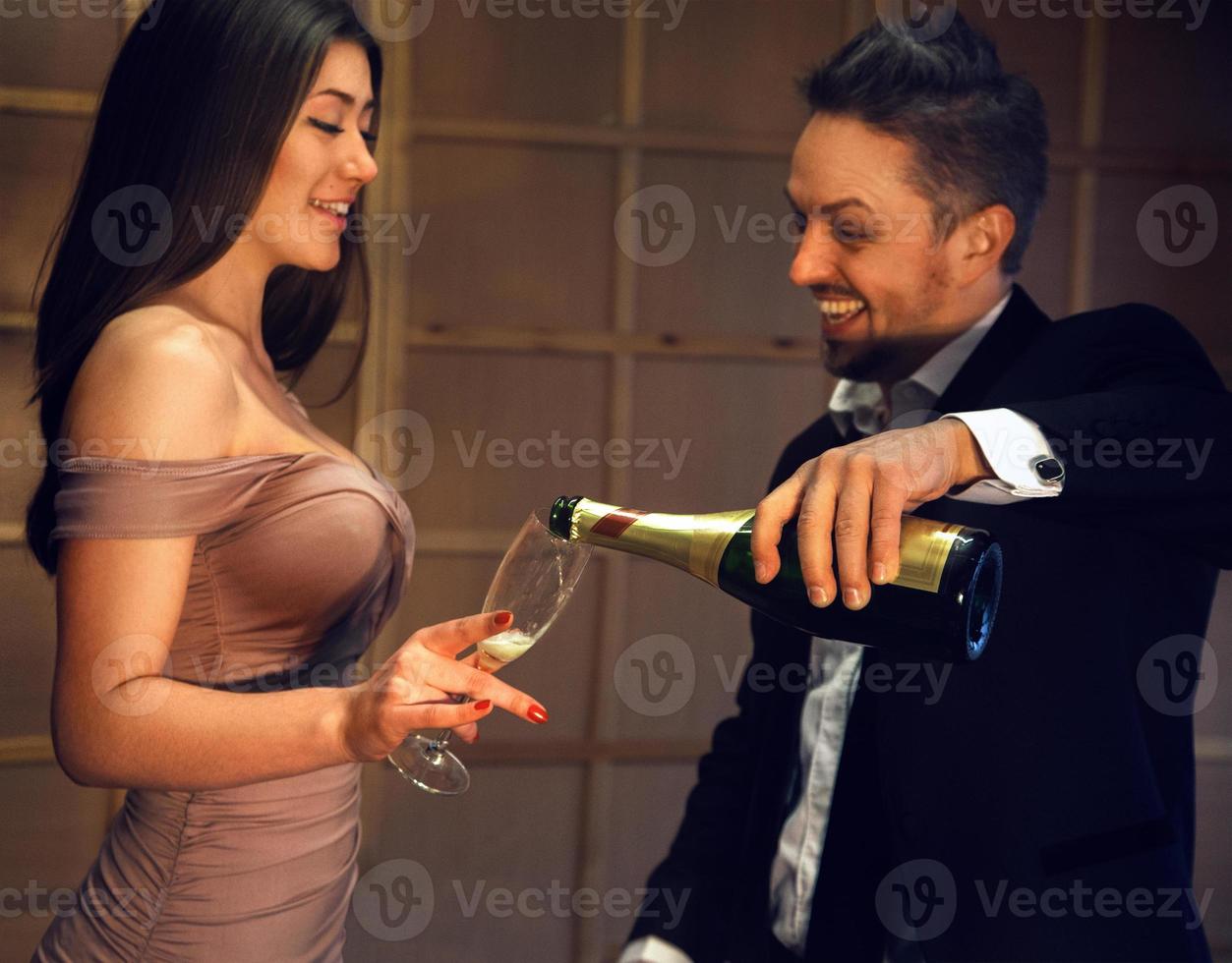 celebrando a una feliz pareja riéndose con una copa de champán foto
