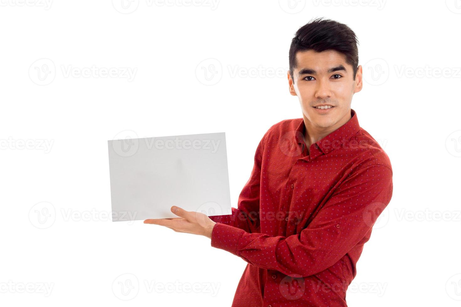 Retrato de un modelo masculino moreno bastante joven con un cartel en las manos aislado de fondo blanco foto