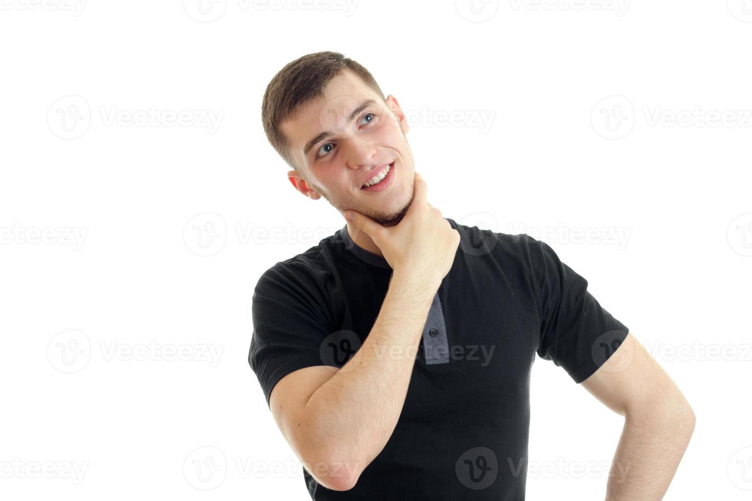 a young thoughtful guy in a black t-shirt and looking up smiling photo