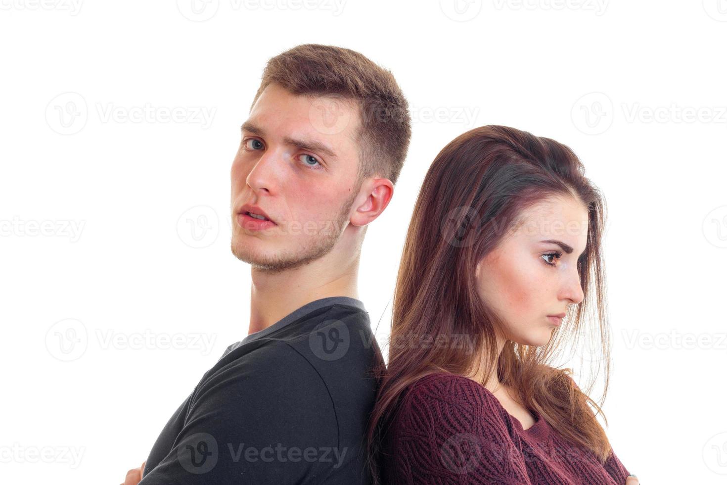 young serious guy with a girl stand each other back close-up photo