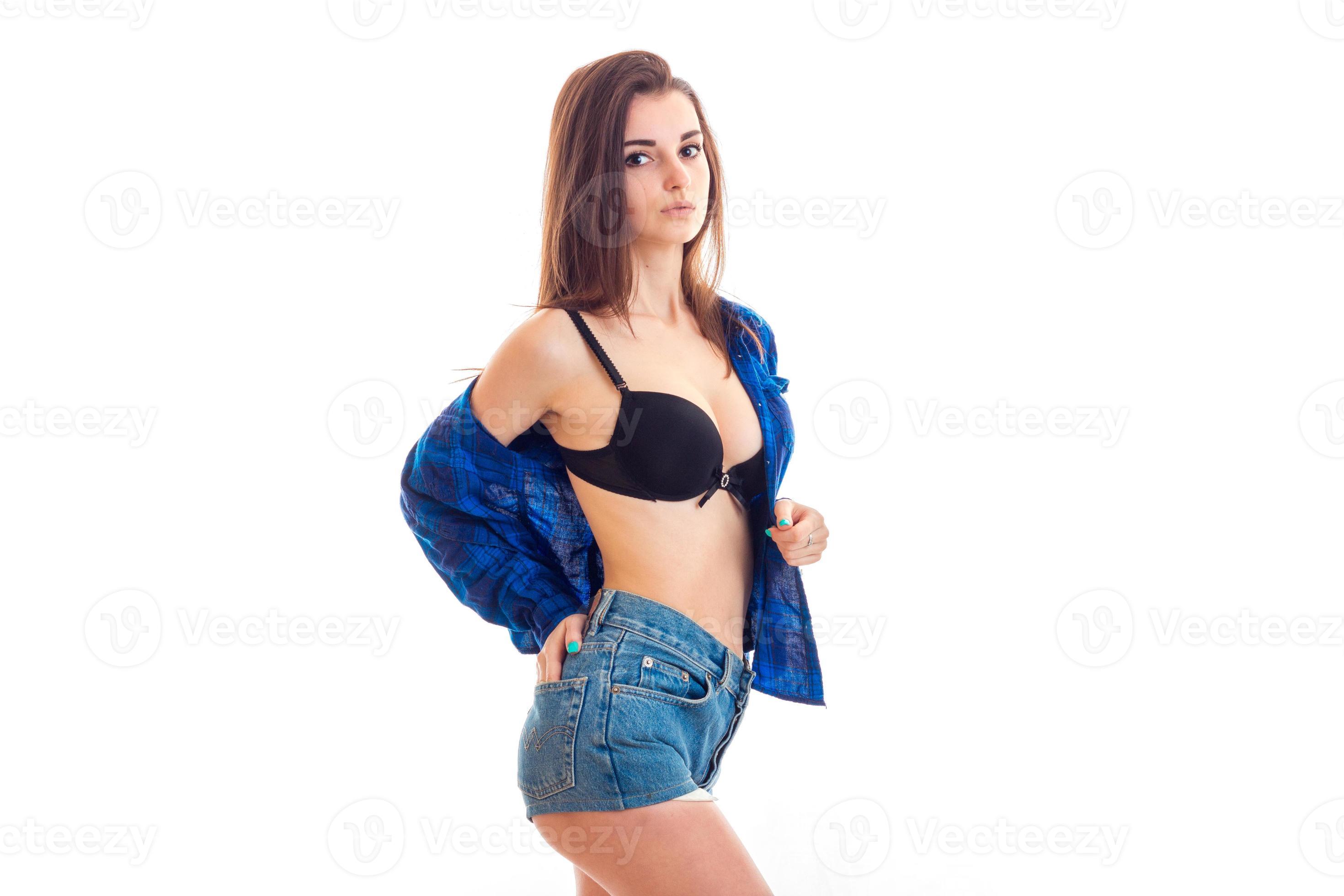 sexy pretty girl stands sideways in shorts and shirt unbuttoned and posing  for the camera 16099271 Stock Photo at Vecteezy