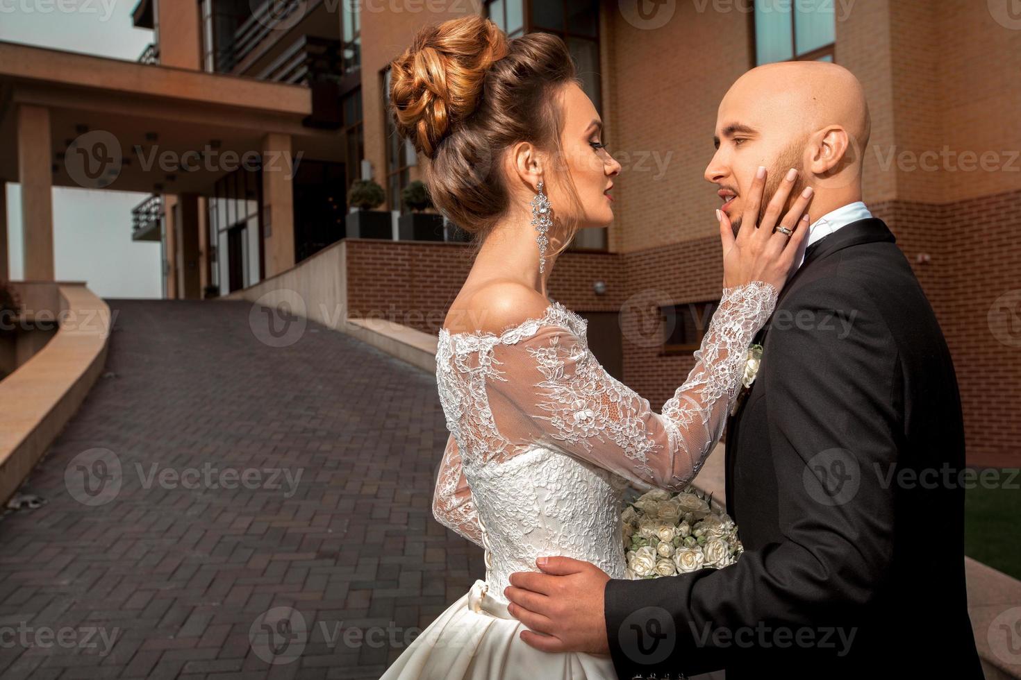 sensual portrait of young beautiful married couple in fashionable wedding suits photo