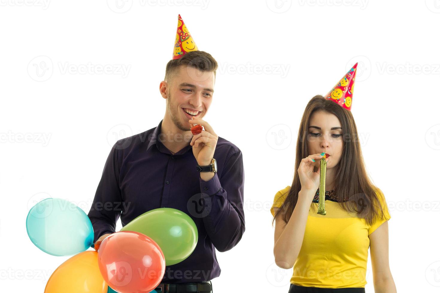 Happy couple blowing in horns and laughing photo