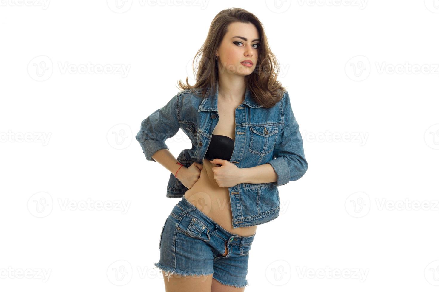 beautiful young brunette in jeans dress and BRA posing on camera photo
