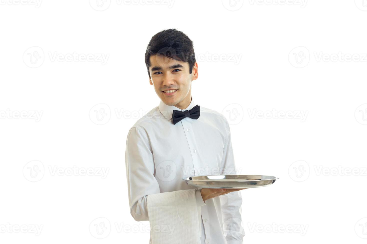 Cheerful brunette waiter man with silver tray in hands smiling photo