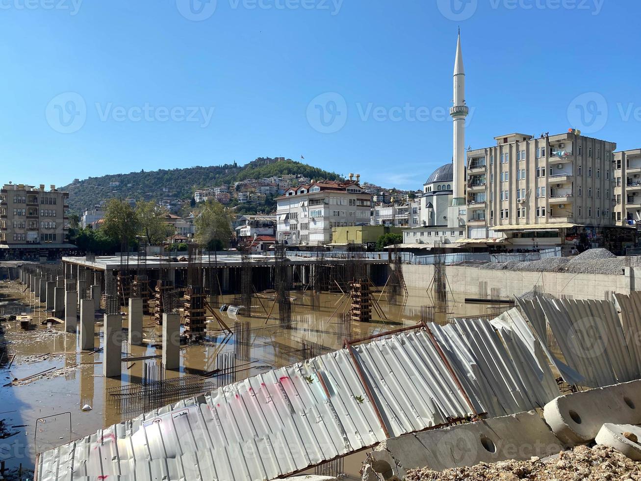 construcción de un edificio de estructura monolítica, cimientos inacabados con columnas de hormigón armado en un lugar de construcción con un pozo inundado foto