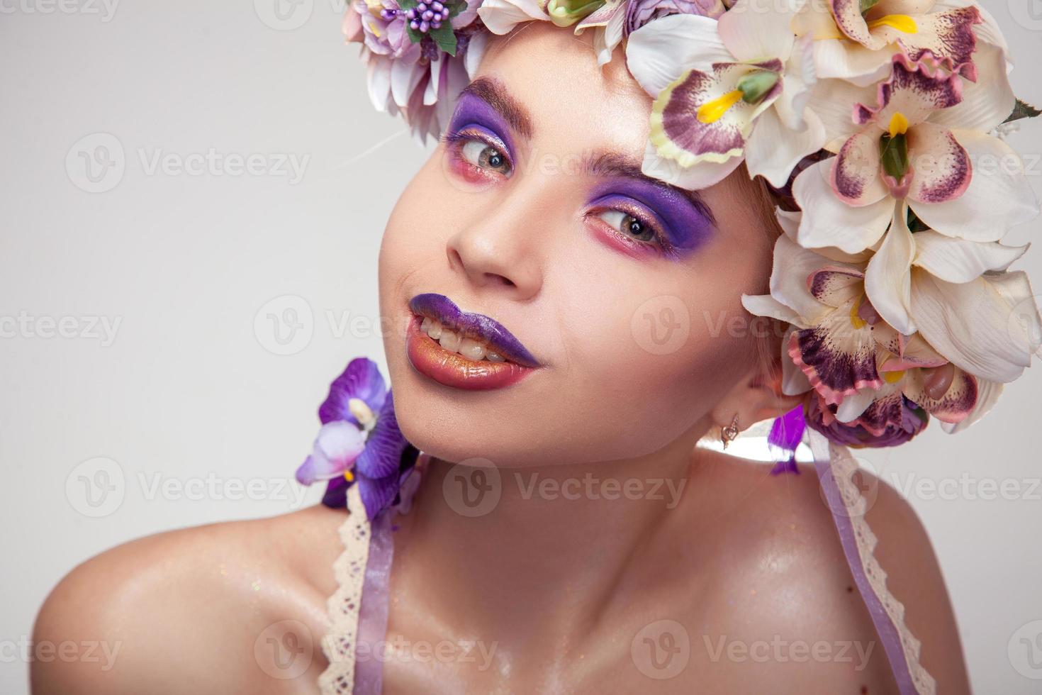 niña feliz con corona en la cabeza y maquillaje en tonos morados foto
