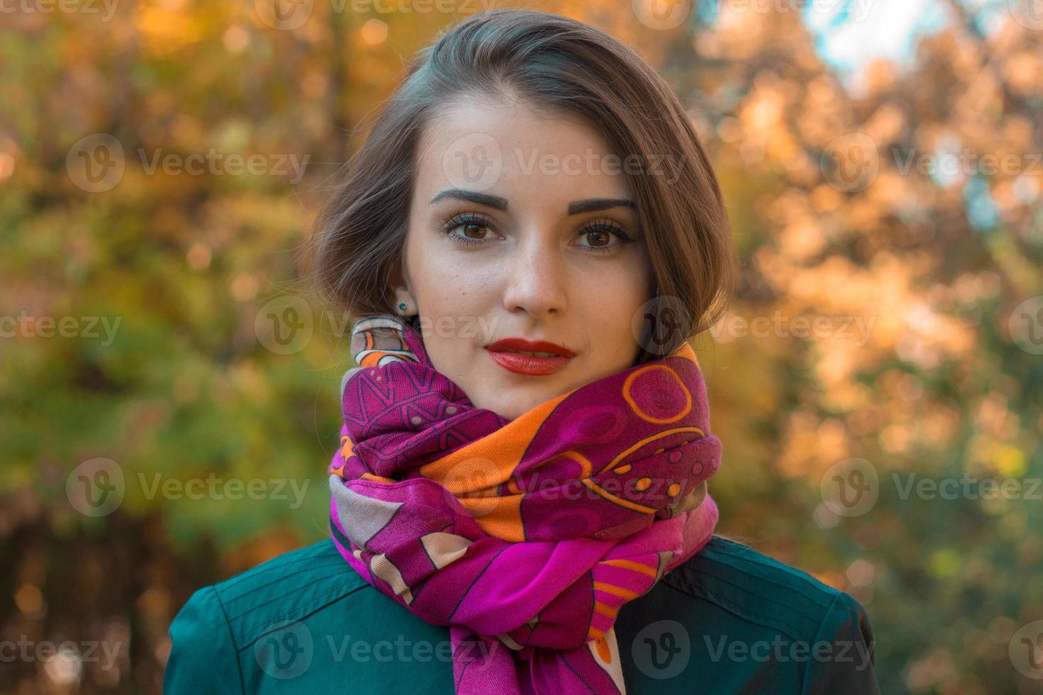 Portrait of a young beautiful girl in  warm pink scarf close-up photo