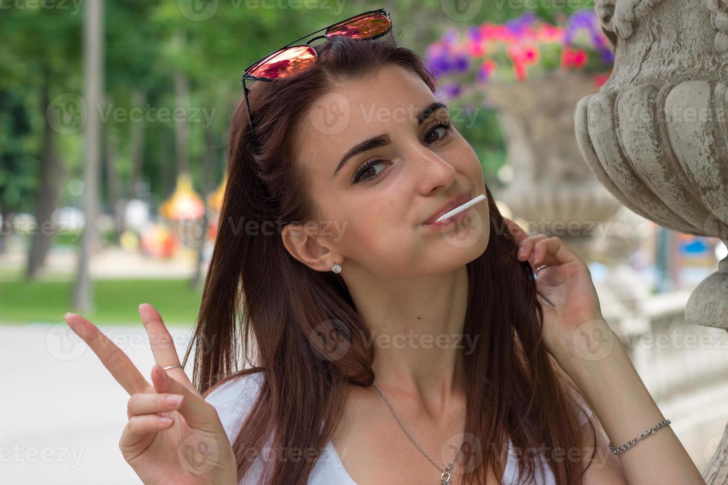 Portrait of a smiling beautiful girl with a lollipop in her mouth photo