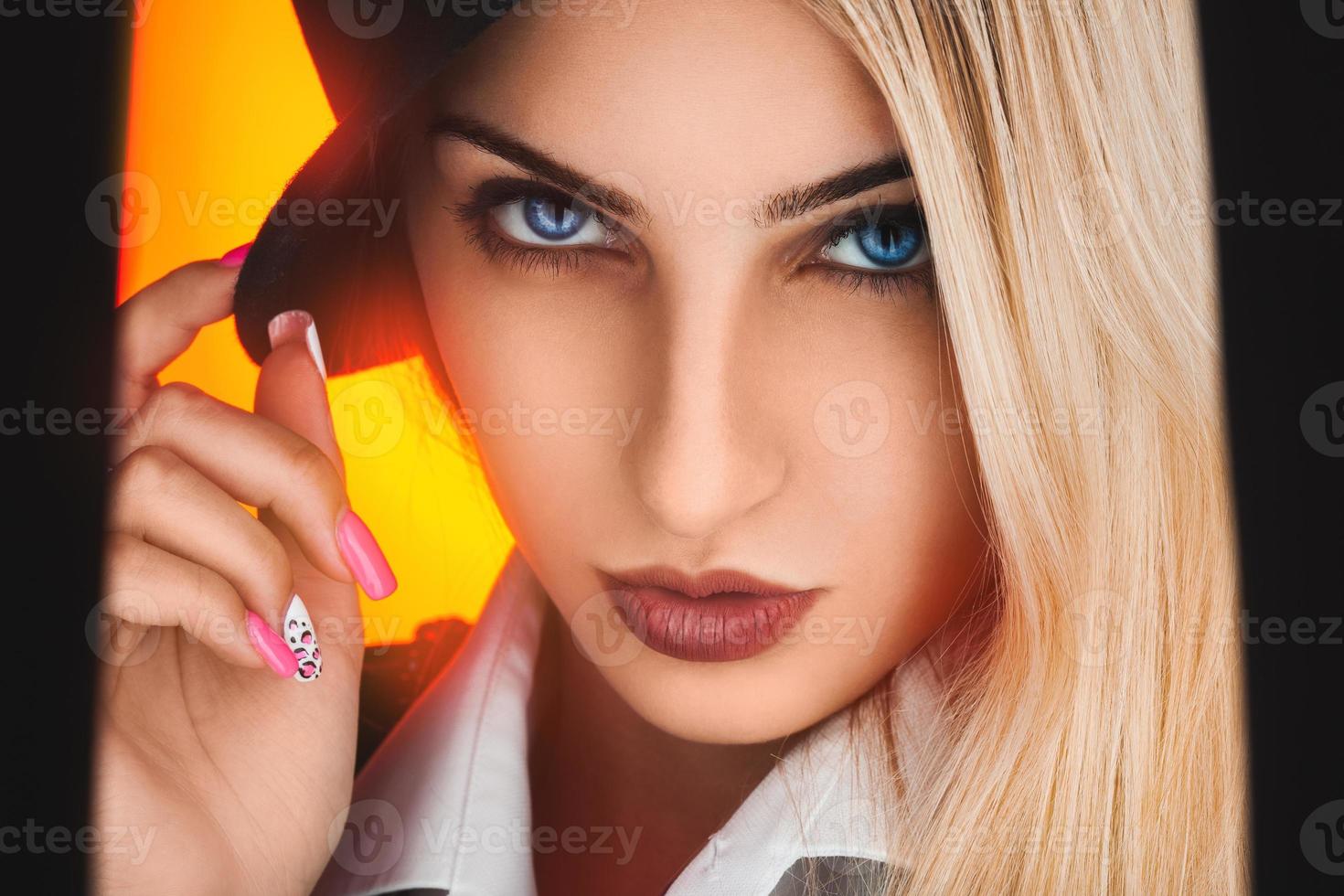 Fashionable portrait of sexy blonde woman with blue eyes on yellow background photo